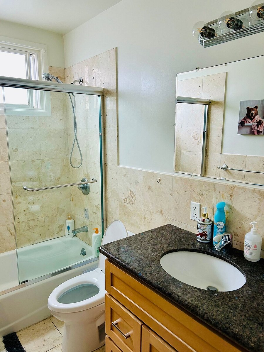 Shared bathroom with tub, shower and granite vanity
