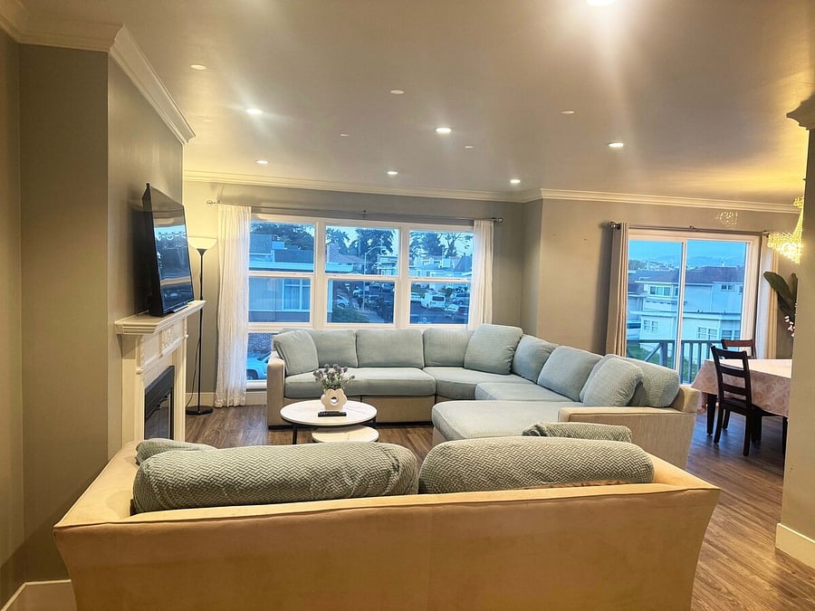 Spacious shared living room with sectional sofa and fireplace