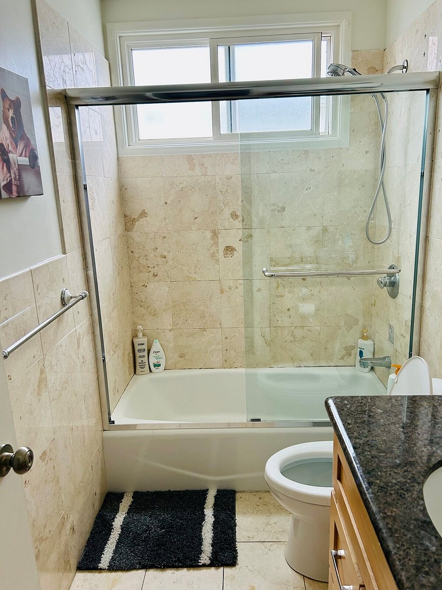 Shared bathroom: bathtub with glass shower door