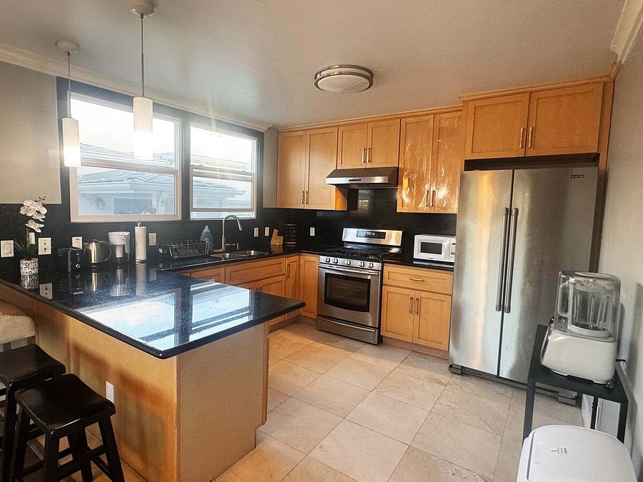 Shared kitchen with stove, oven and stainless steel fridge