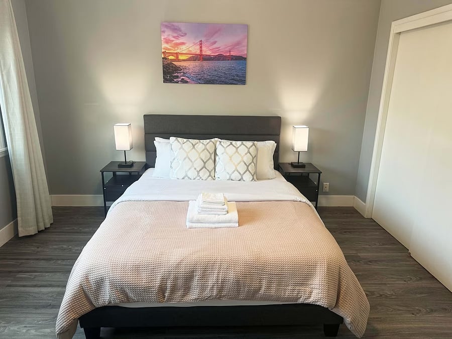 Room 2 ($1,900/mo): Spacious private bedroom with large window and comfortable bed