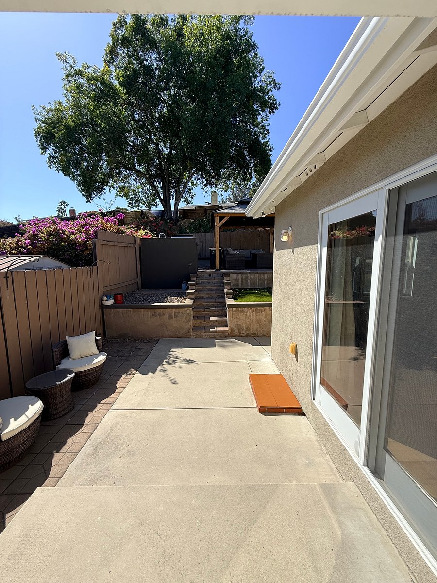 Acces to the backyard from the laundry room. Outdoor kitchen and BBQ straight ahead and above, with large wood gazebo covering a furnished patio