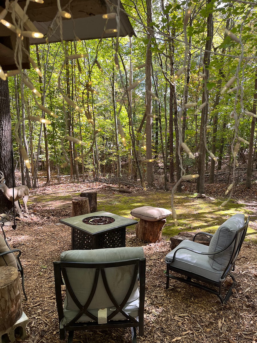 Propane fire table. Chairs for enjoying the wooded backyard