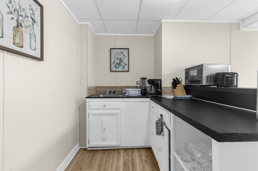 The downstairs kitchen offers a convenient second space for preparing meals, complete with an oven and microwave. While it doesn't include a dishwasher, it's thoughtfully set up to handle everything from quick snacks to full dinners.