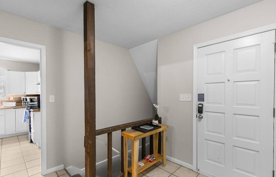 Step inside to a bright, welcoming entryway with stairs leading to the lower level, giving you a glimpse of the home's spacious, multi-level layout.