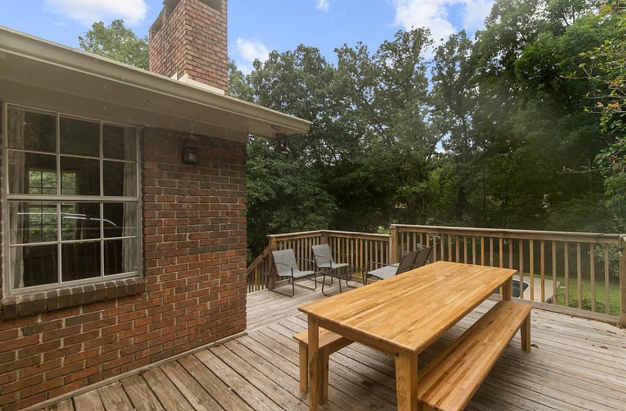 The back porch offers a relaxed outdoor setting where the picnic table becomes a natural gathering spot-perfect for shared meals, morning coffee, or winding down together in the fresh air.