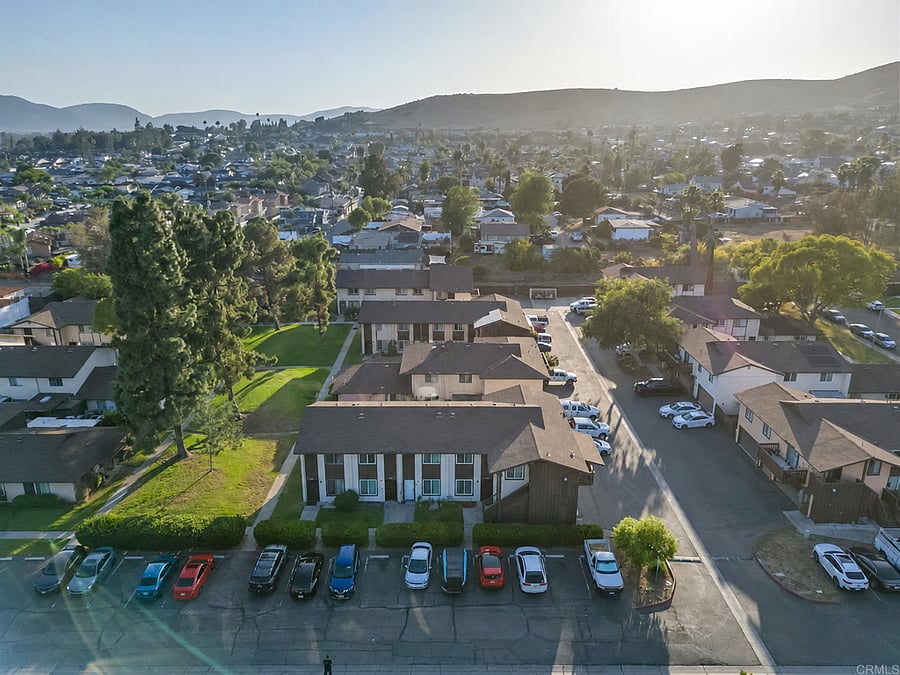 Bird's-eye view of the condo community, surrounding Santee hills, and parking area beside the building