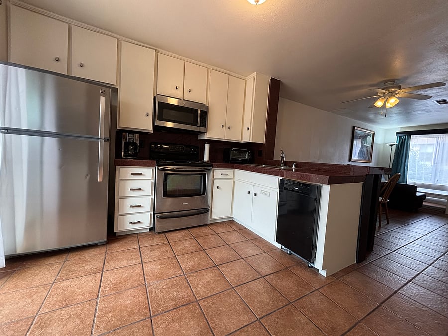 Fully stocked kitchen with a full-size refrigerator, stove and oven, microwave, and dishwasher. The open counter connects the kitchen to the dining and living areas