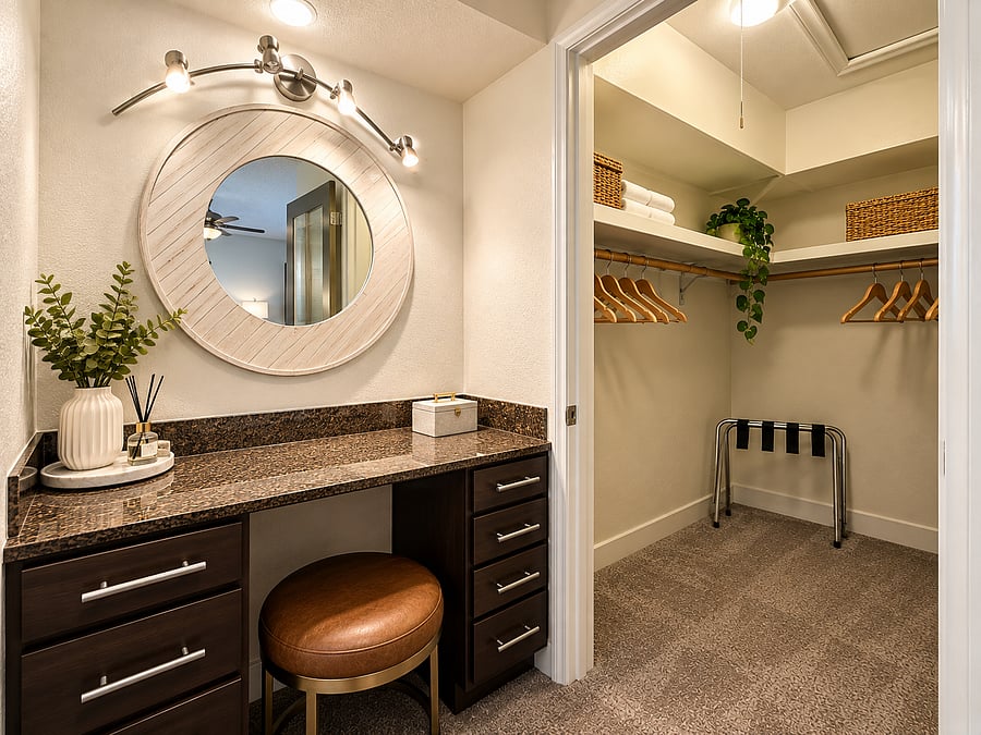 Dedicated vanity area with generous counter and drawer space, conveniently connected to a spacious walk-in closet with ample shelving and hanging storage.