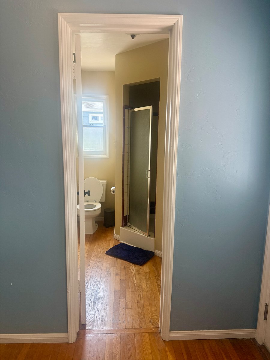 View of the bedroom opening into the private bathroom with walk in shower.