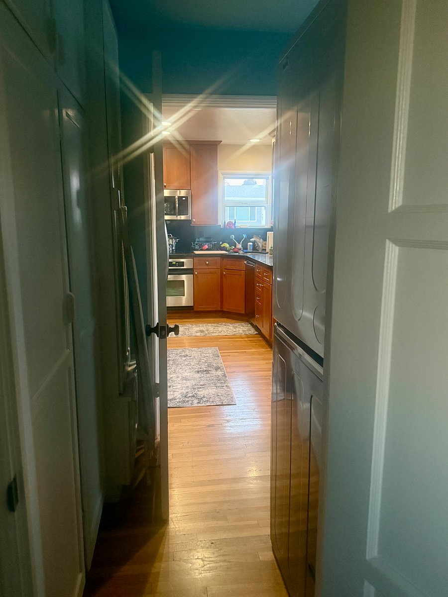 View of bathroom looking into the laundry room and kitchen.