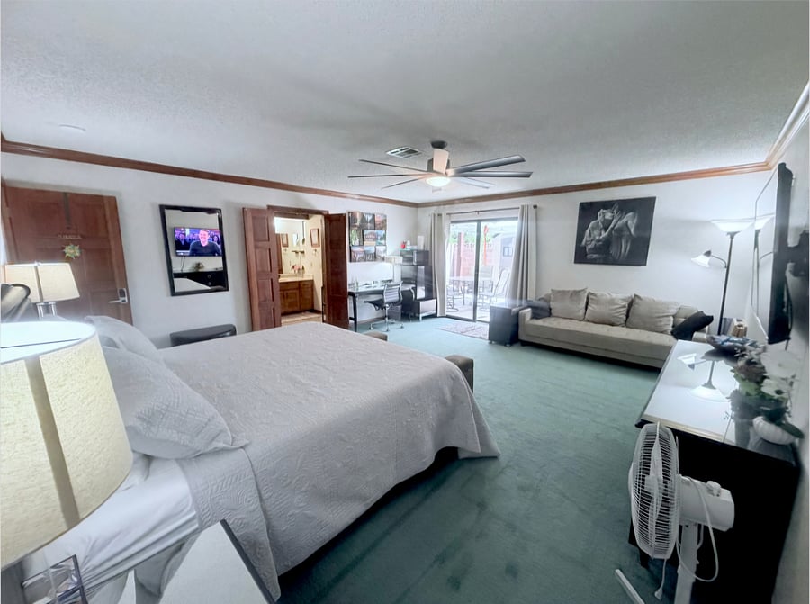 Massive 425 sqft primary suite featuring a comfortable king - size bed, a private sofa seating area, a 55" smart TV, private en-suite bathroom,walk-in closet, dedicated desk workspace.