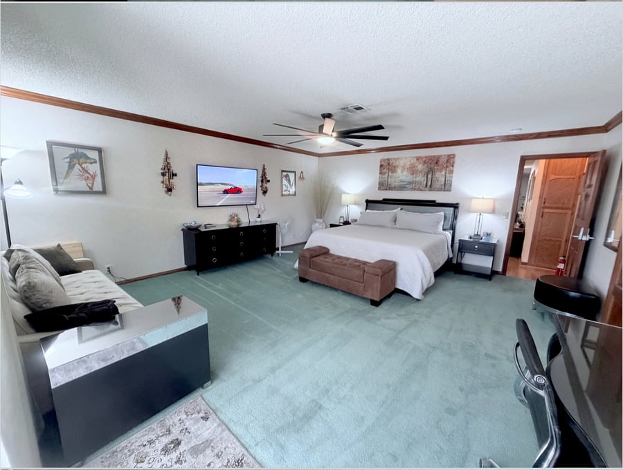 Massive 425 sqft primary suite featuring a comfortable king - size bed, a private sofa seating area, a 55" smart TV, private en-suite bathroom,walk-in closet, dedicated desk workspace.
