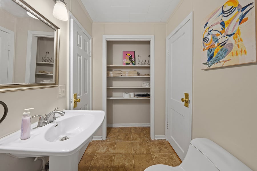 Well-appointed bathroom layout with a spacious built-in closet fully stocked with fresh towels and essential amenities.