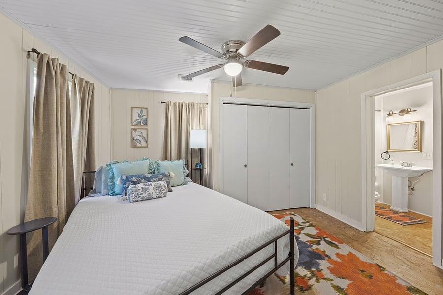 Inviting secondary bedroom featuring a comfy bed, vibrant decor, and direct attached bathroom access.