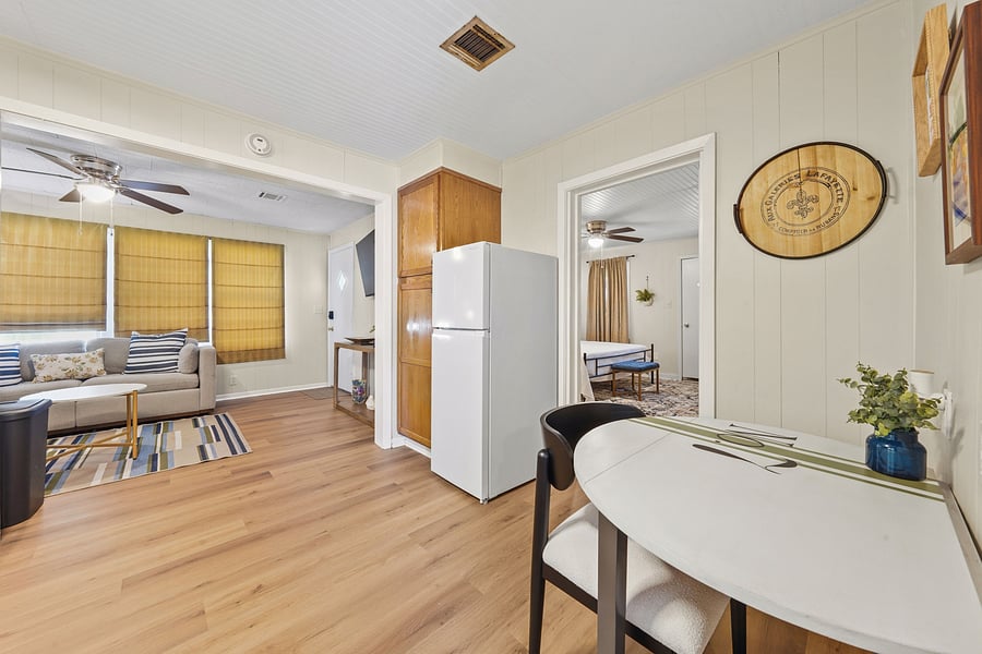 Bright, open-concept layout connecting the cozy living area, kitchen, dining/office nook, and primary bedroom.
