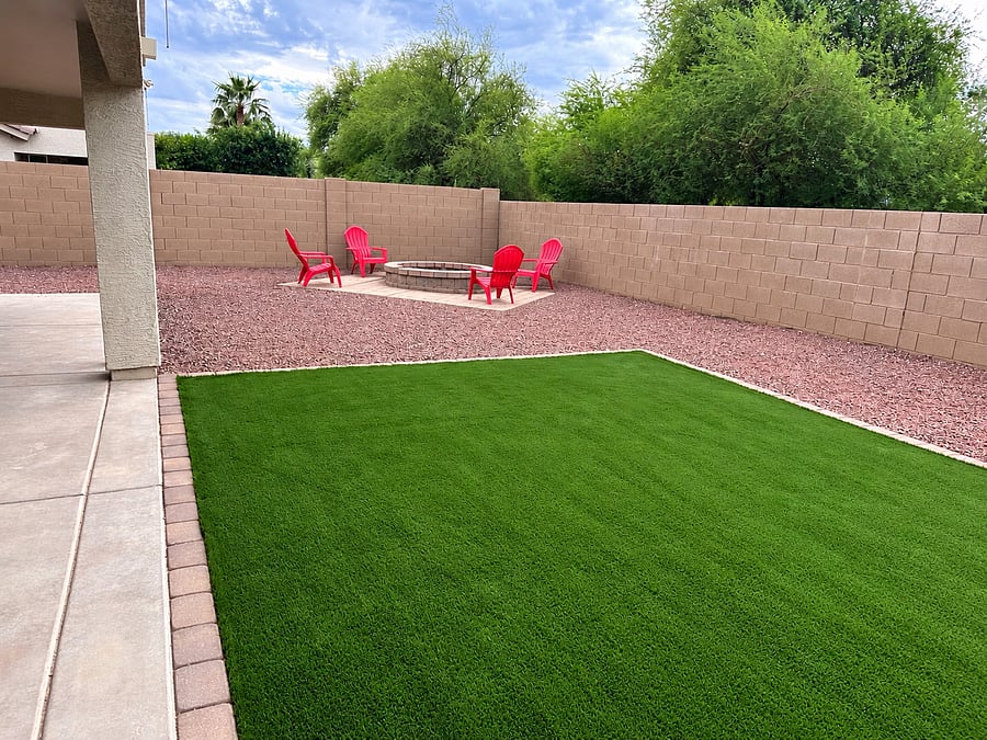 Large, private, fenced backyard has fire pit, grassy area, covered patio with comfy seating and dining table, BBQ area and plenty of room for play!