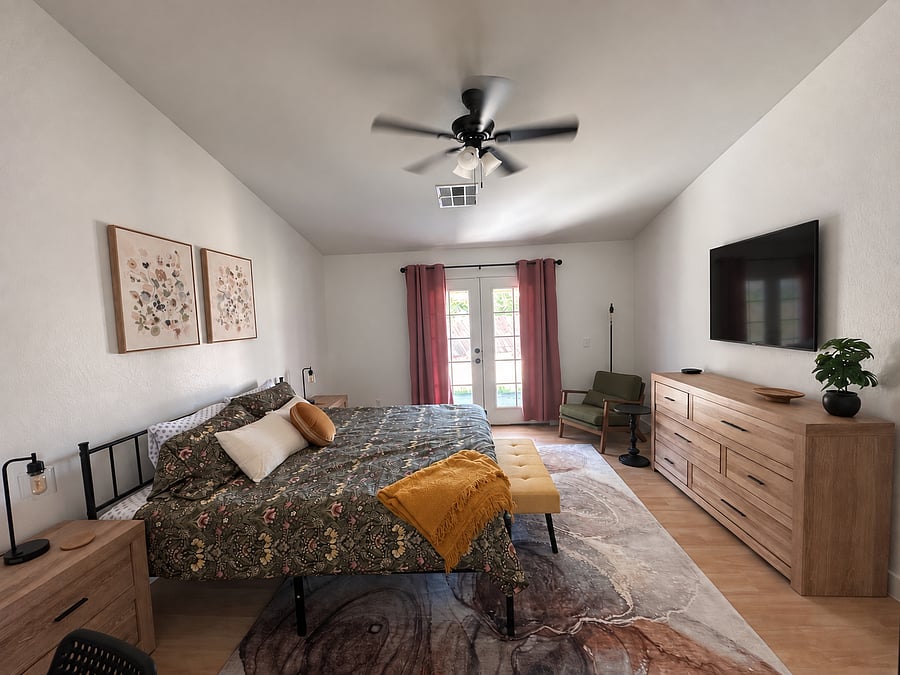Primary bedroom with King bed and ensuite bathroom includes mounted smart tv, private desk, dressers, walk-in closet, and all the quality bedding of home!