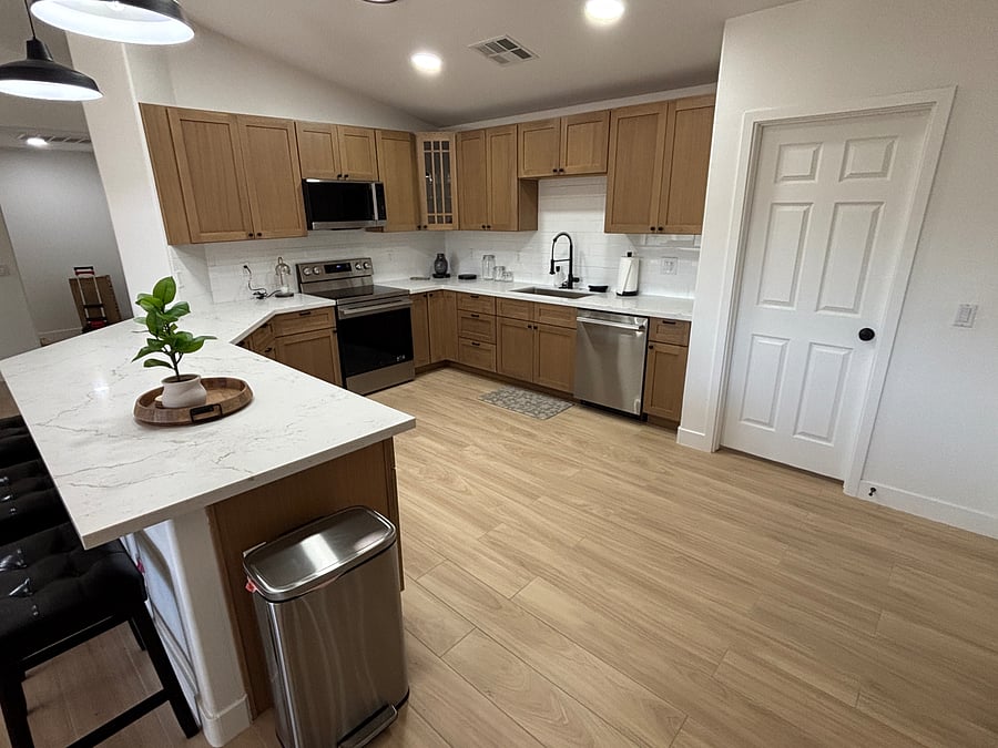 Beautifully remodeled kitchen with warm oak cabinetry, quartz counters, stainless steel appliances and stocked cooking/serving supplies including gorgeous coffee bar