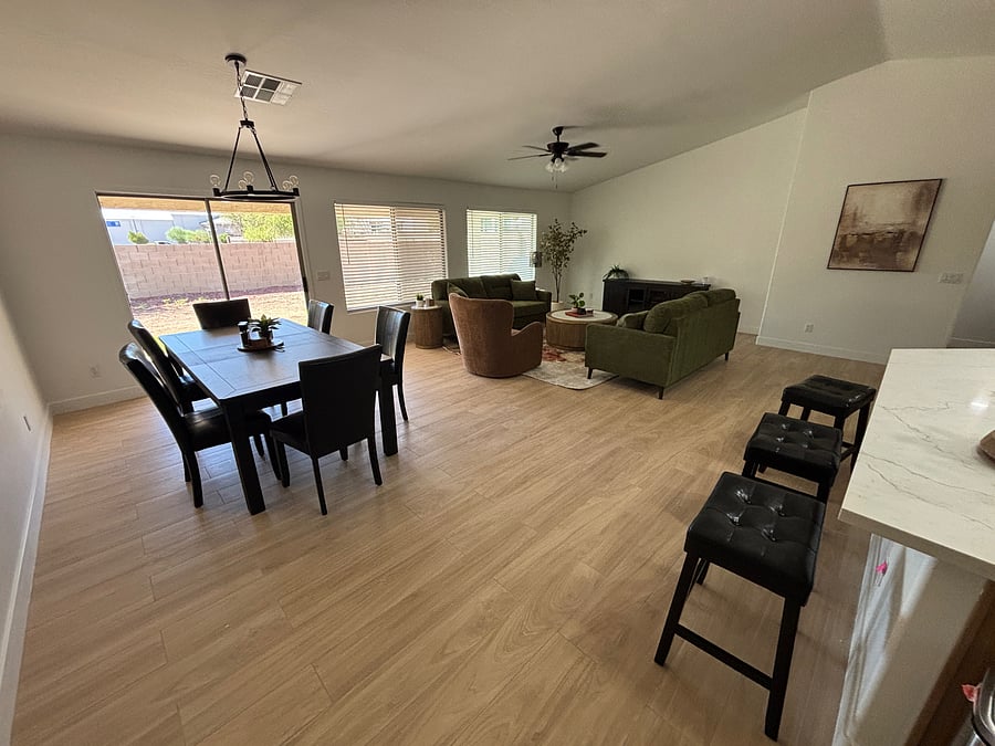 Large, inviting family room with seating for 8 at the dining table and additional bar seating