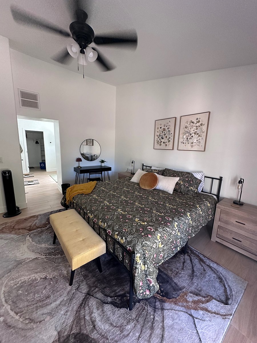 Primary bedroom with King bed and ensuite bathroom includes mounted smart tv, private desk, dressers, walk-in closet, and all the quality bedding of home!