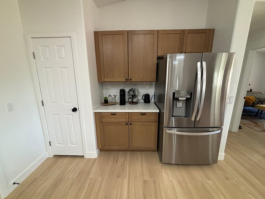 Beautifully remodeled kitchen with warm oak cabinetry, quartz counters, stainless steel appliances and stocked cooking/serving supplies including gorgeous coffee bar
