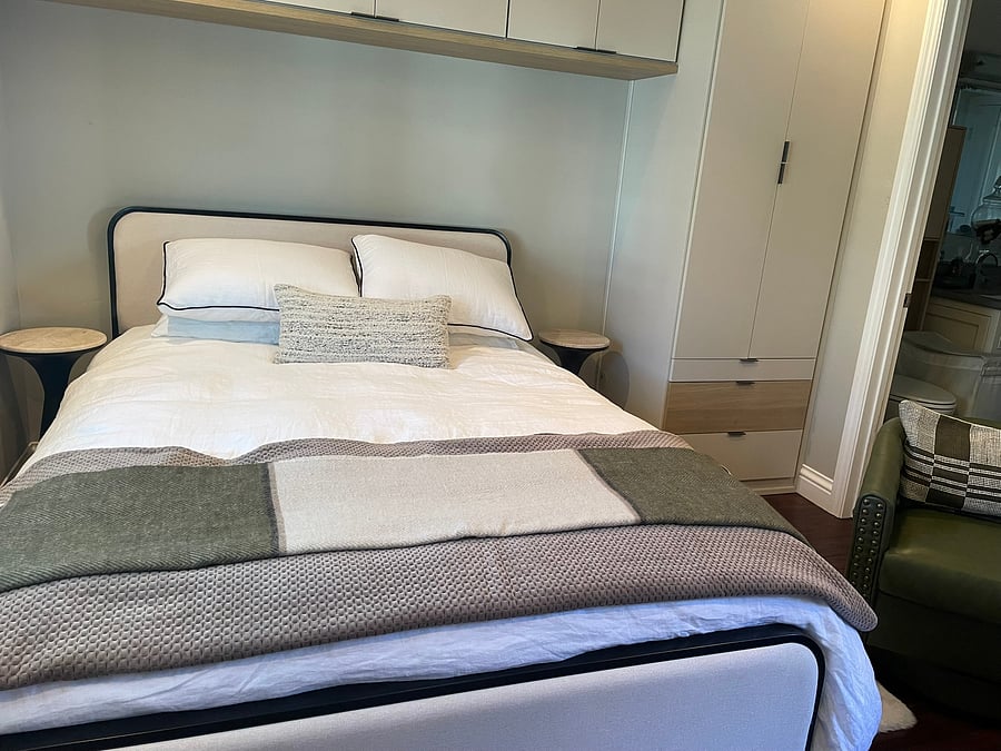 Designed for rest and relaxation with plush bedding, neutral tones, and convenient built-in bedside reading setups.