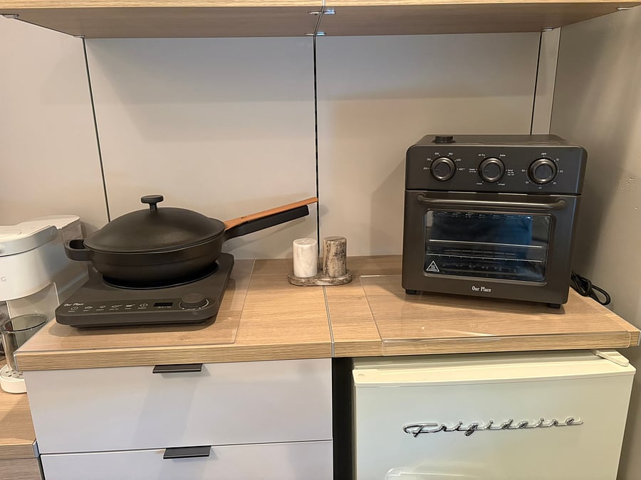 Prepare meals easily with a portable induction burner (2), Our Place pans, toaster oven/air fryer combo, and retro mini fridge. Can customize your set up as you desire with the option to put a microwave in this space.