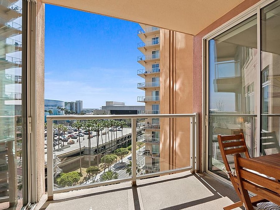 Spacious shared balcony with outdoor seating, accessible from both the main living area and each bedroom