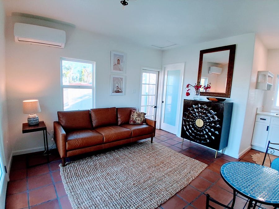Open concept space flows into kitchenette area Leather loveseat, Mr Cool heating and AC unit, back door leads to BBQ area.