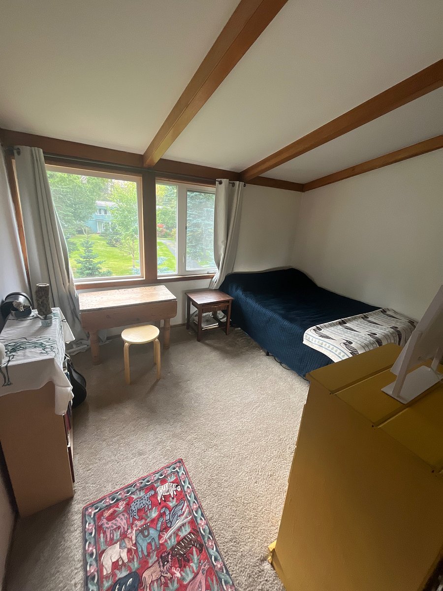Full bed in a room with blackout shades and multiple drawers for storage