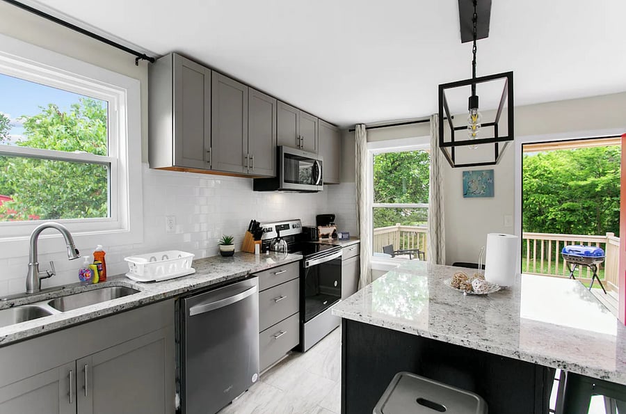 Cook, gather, and connect in a fully stocked kitchen featuring sleek granite countertops and a spacious island perfect for prepping, serving, or casual seating.