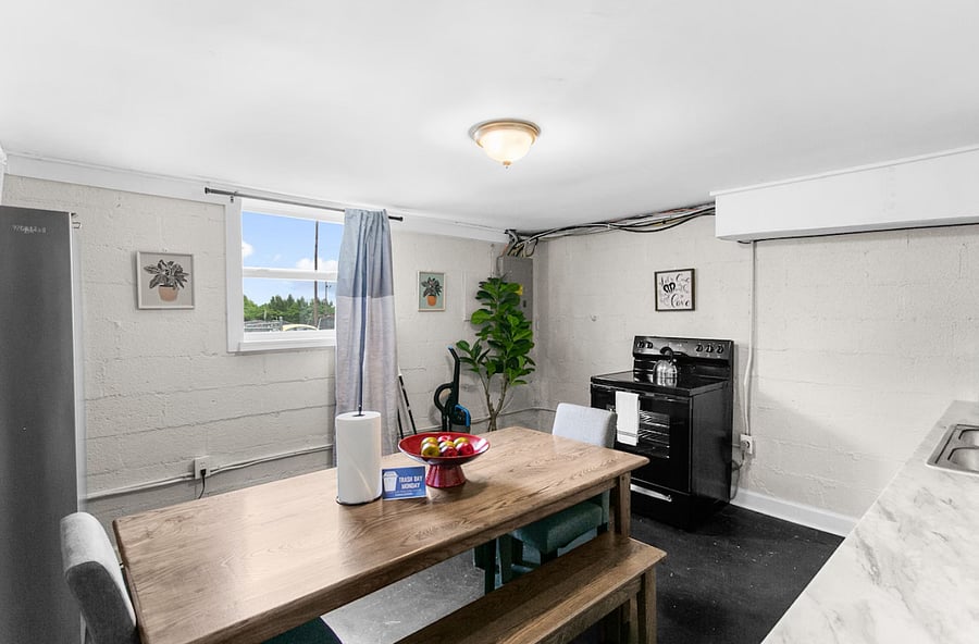 Enjoy a cozy dining space right in the heart of the kitchen in Unit B, featuring a farmhouse table that makes every meal feel inviting.