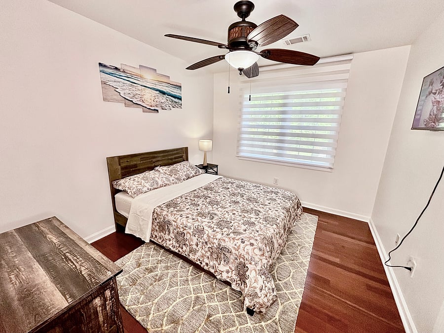 Quiet second bedroom with Full bed, ceiling fan, 32" smart tv, and zebra window shades for privacy.
