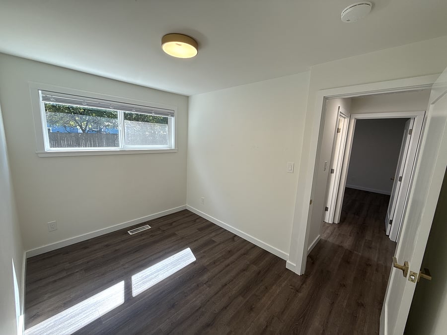 The bedroom that faces the backyard, next to the bathroom.