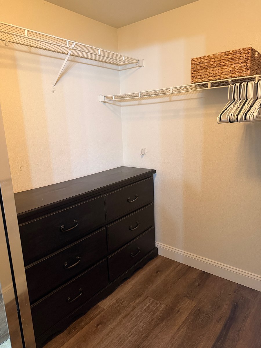 Full walk in closet with a 6 drawer dresser. Closet is next to bathroom sinks.