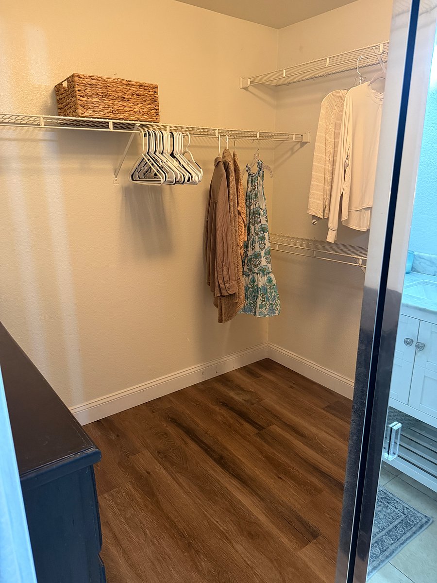 Walk in closet with long item rack and 3 half sized racks for your clothes.