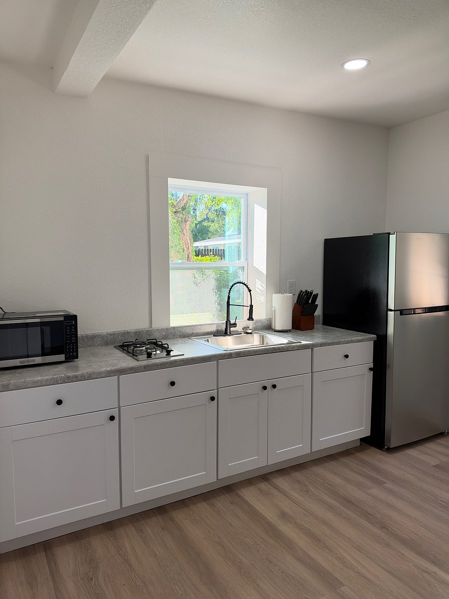 Your fully stocked kitchenette. Stored away are items such as plates, bowls, flatware, cutting boards, cooking utensils and pots and pans.