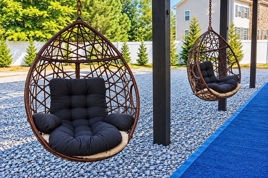 Sink into a generously cushioned hanging chair and enjoy a moment of calm in the fresh air. Sculptural woven frames, soft seating, and surrounding greenery make this outdoor nook a beautiful spot for reading or simply relaxing.