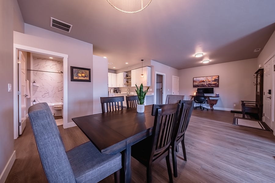 View of kitchen, dining area, office/entry area, and guest bath from living room sofa.