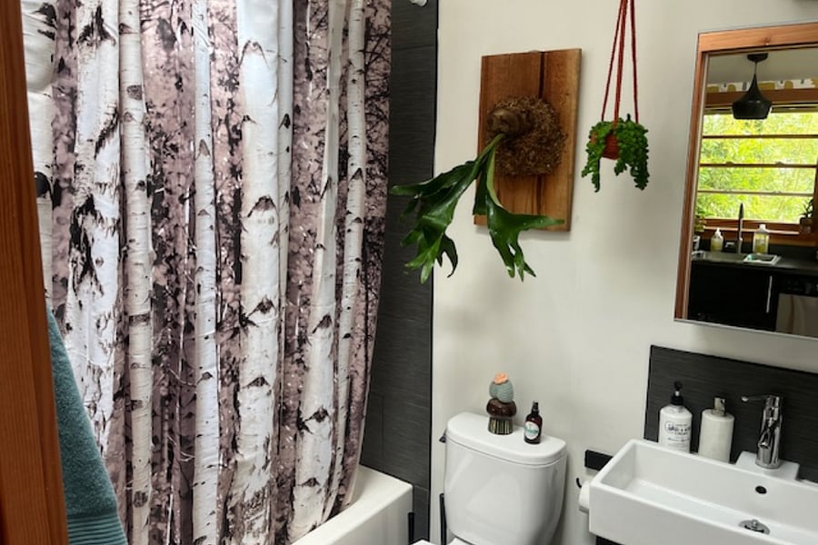 Bathroom- tub/shower, small sink & cabinet. Skylight provides natural light