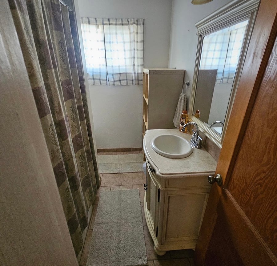 Beautiful bath room with shower bathtub shelves above and across from the toilet area, marble vanity area.