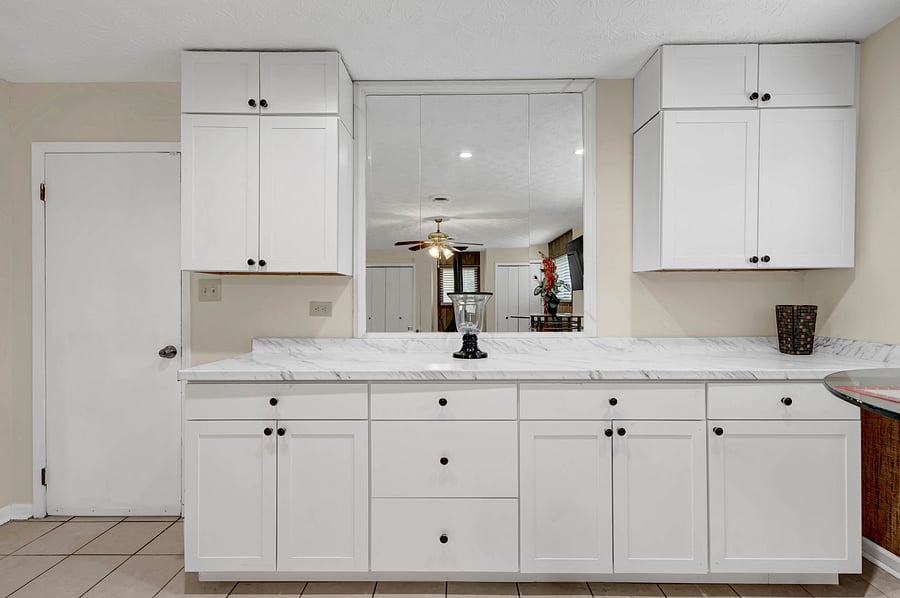 Plenty of cabinet and drawer storage, with spacious countertops and a mirrored wall that makes the space feel open and bright.