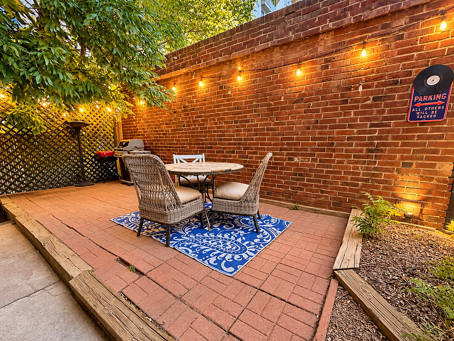 Shared outdoor patio with string lights, dining area, and grill-perfect for relaxing or enjoying a meal outside.