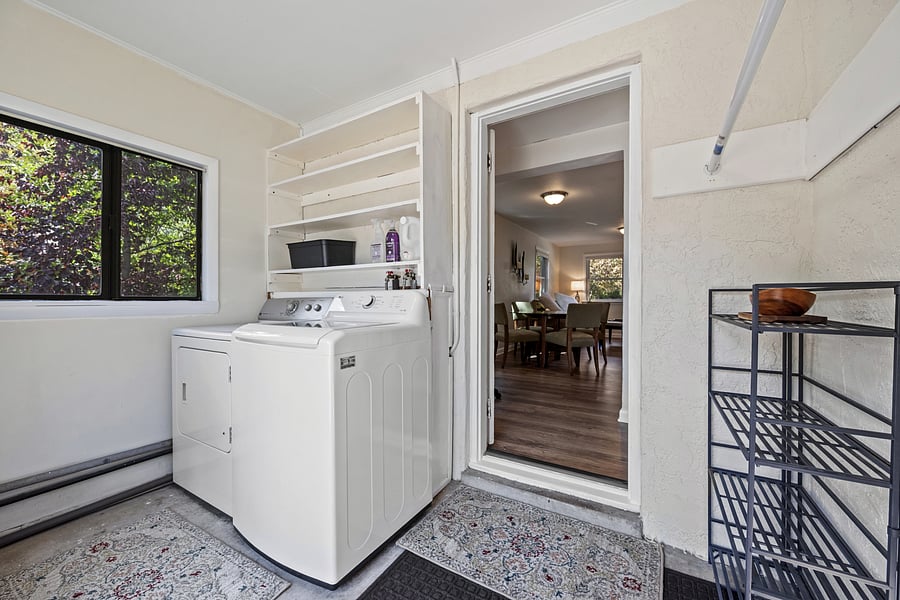 Spacious laundry and mud room with storage and hangers.