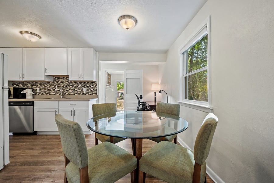 Breakfast area with glass top table and comfortable chairs.
