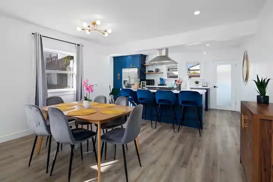 Bright dining room and kitchen with bar and modern stainless steel appliances.