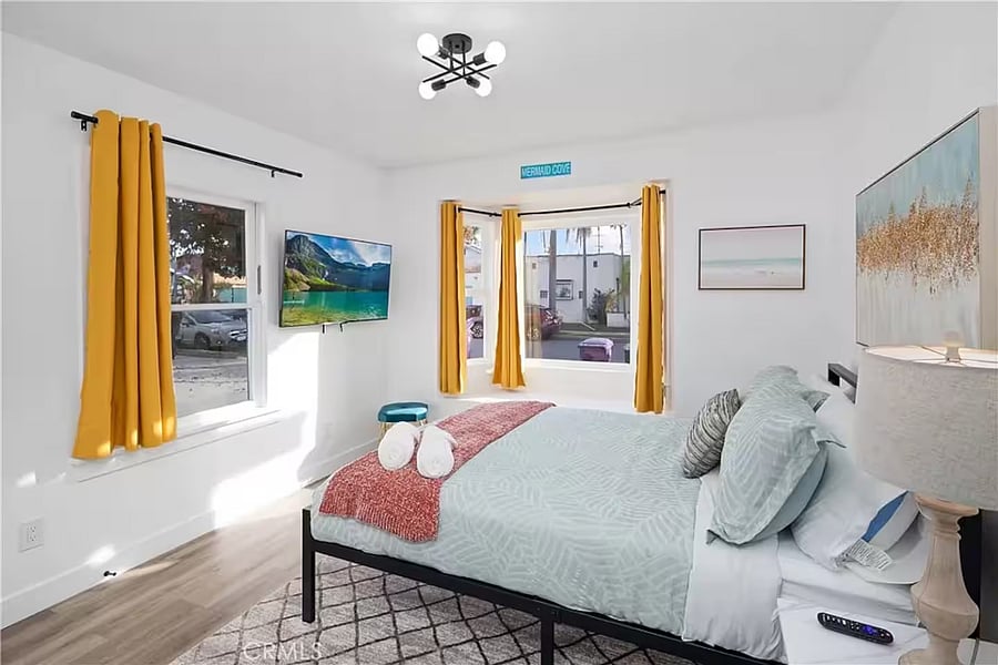 Light and airy bedroom with reading nook and queen bed.
