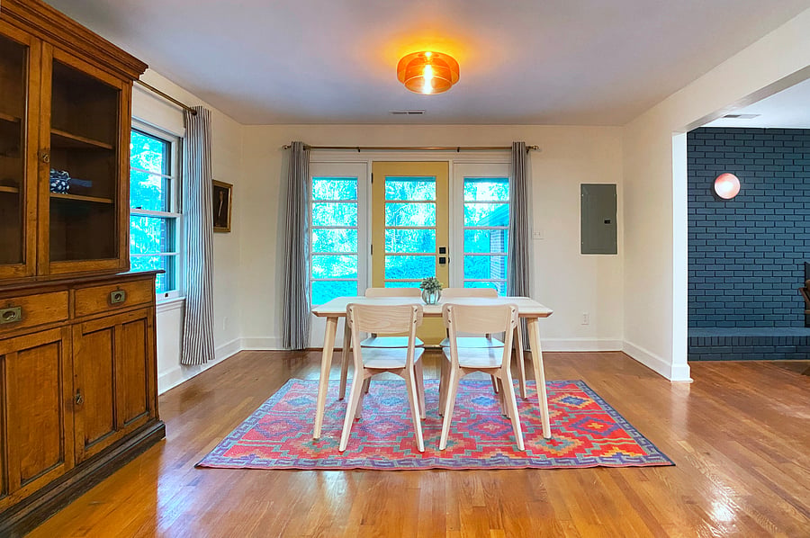Dining room with antique sideboard. Door to back patio.