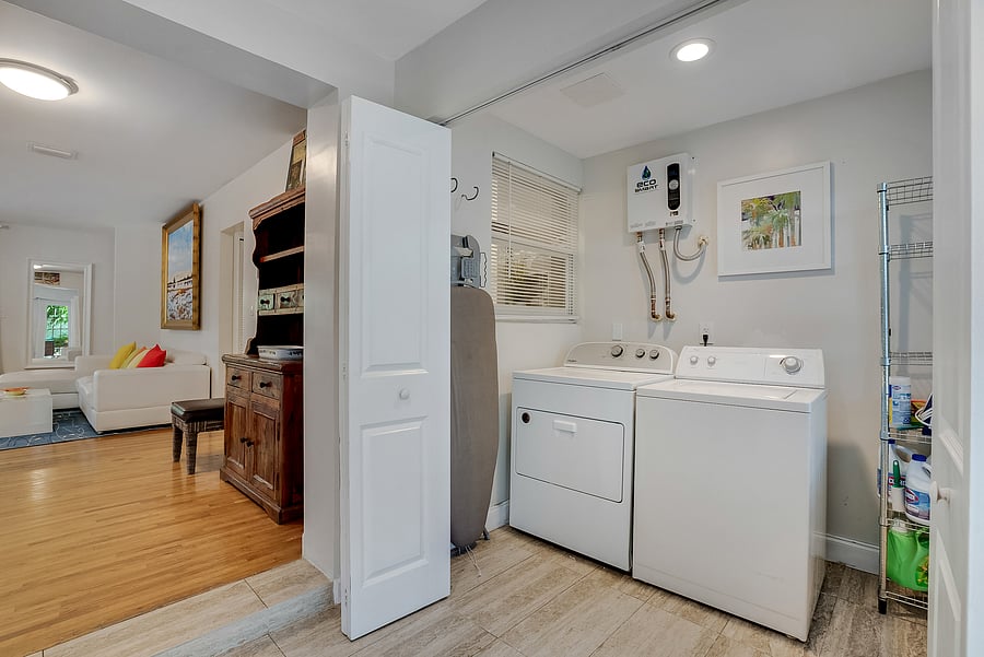 Laundry room with ironing board and storage space.